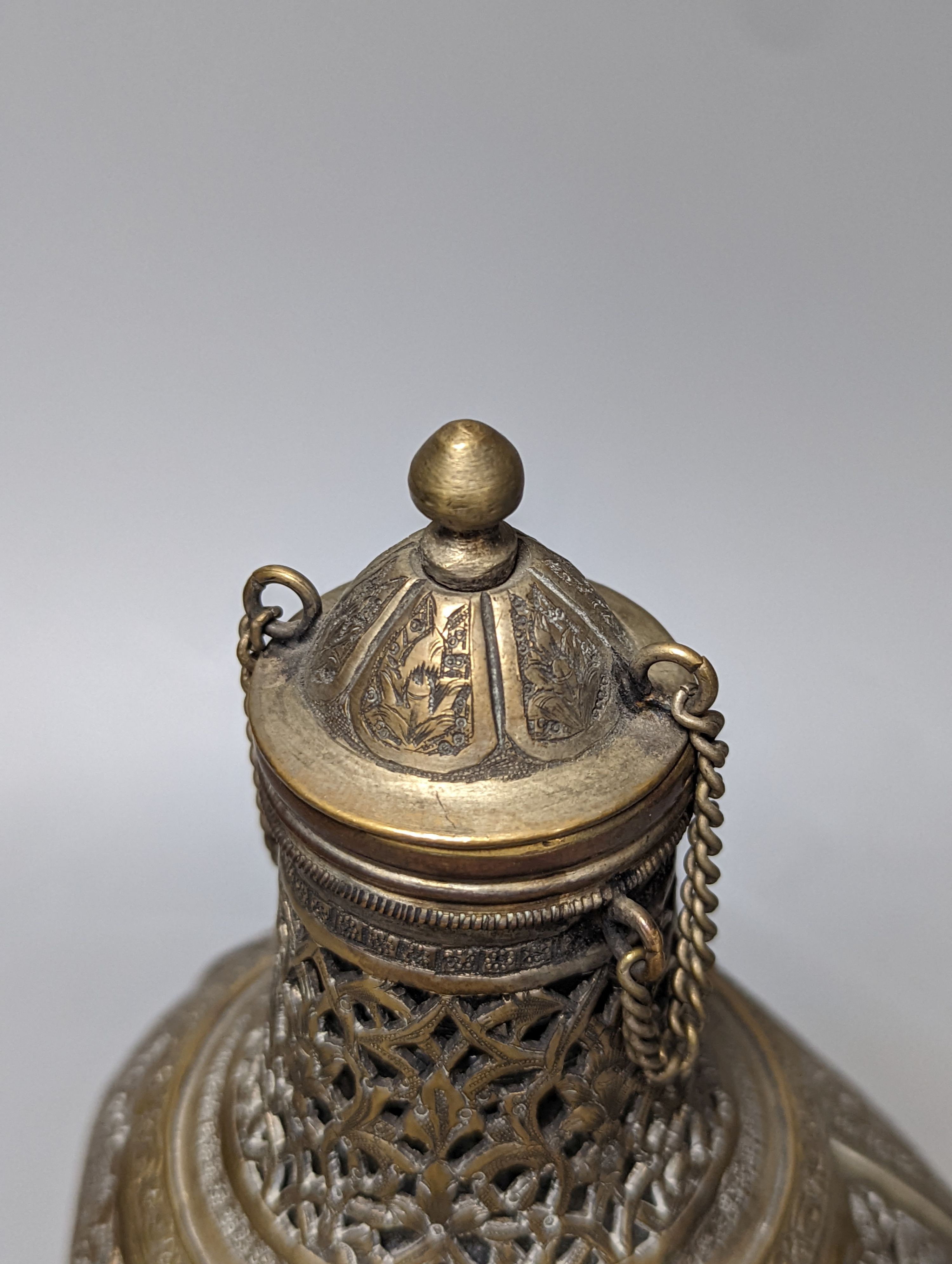 A Persian pierced brass cased glass dimple bottle 23cm